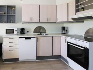 a kitchen with white cabinets and a white dishwasher at 6 person holiday home in Hadsund in Hadsund