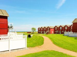 une rangée de maisons rouges avec une clôture blanche dans l'établissement Seaside Retreat in oster Hurup-By Traum, à Hadsund