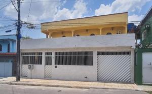 a building with two garage doors on a street at Apto 2 - Hospedagem da Almira in Manaus