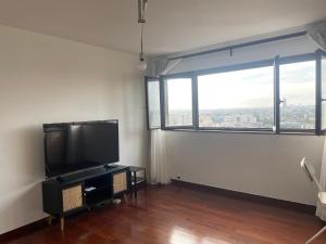 a living room with a large window and a flat screen tv at Appartement stunning view Paris in Courbevoie