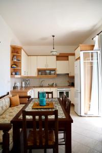 a kitchen with a table and chairs and a kitchen with a couch at View & Chill Syros in Vári +13 photos