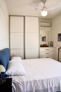 a bedroom with a white bed with a sliding glass door at View & Chill Syros in Vari