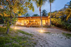 a house on the beach with palm trees and lights at Casa Yemanjá in Acaraú