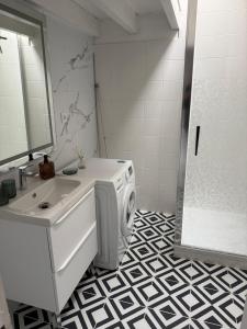 a bathroom with a sink and a washing machine at Maison aux portes de la Sologne in Marcilly-en-Villette