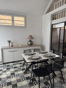 a dining room with a table and chairs and a tv at Maison aux portes de la Sologne in Marcilly-en-Villette