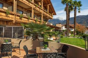 a patio with a table and chairs and mountains at MONDI Hotel Tscherms in Cermes