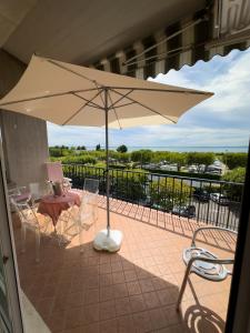 a table and chairs with an umbrella on a balcony at Appartamento Giulietta in Bardolino +7 photos