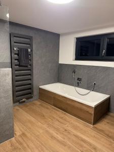 a bathroom with a bath tub in a room at Spessart Chalet in Dammbach +16 photos