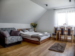 a bedroom with a bed and a couch and chairs at Apartamenty u Beci I Cyryla in Nowa Biała