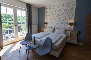 克罗夫Der Weinladen的一间卧室，里面有一张床和两把蓝色椅子