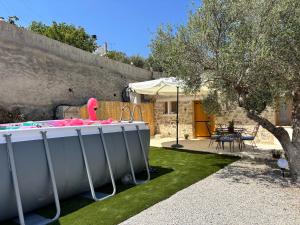 a backyard with a hot tub in the grass at Erofili Traditional House in Pómbia