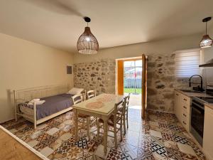 a bedroom with a bed and a table and a kitchen at Erofili Traditional House in Pómbia