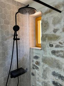 a shower in a bathroom with a shower curtain at Erofili Traditional House in Pómbia +12 photos