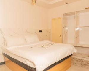 a bedroom with a white bed and a window at Moro Fuvahmulah in Fuvahmulah