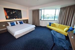 ein Hotelzimmer mit einem Bett und einer Couch in der Unterkunft Kepler Residence in Bukarest + 21 Fotos