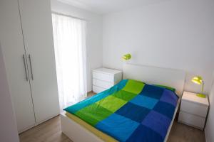 a bedroom with a bed with a colorful blanket at Apartments Irina in Ičići