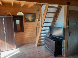 a living room with a staircase and a television at Agroturystyka u Krystyny in Rybczewice