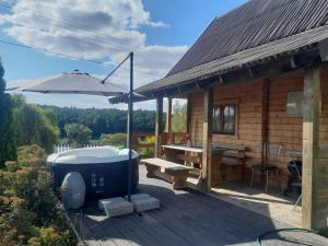 a wooden cabin with a hot tub and a picnic table at Agroturystyka u Krystyny in Rybczewice