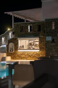 a stone building with a kitchen and a pool at night at Nodo Boutique Hotel in Mýkonos City
