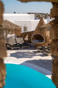 a view of a swimming pool with chairs and umbrellas at Nodo Boutique Hotel in Mýkonos City