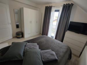 a bedroom with a large bed and a television at Kve Apartment in Iaşi