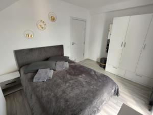 a bedroom with a large bed and white walls at Kve Apartment in Iaşi +16 photos