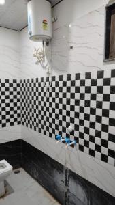 a bathroom with a black and white checkered wall at Shree Bankey Bihari Atithi Bhawan in Mathura
