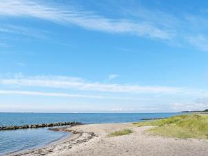 a beach with the ocean and a blue sky at 5 person holiday home in Rødby-By Traum in Rødby +13 photos