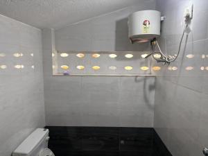 a bathroom with a toilet and a window with lights at Rainbow721 in Pondicherry +21 photos