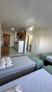 Zimmer mit 2 Betten und einer Küche mit Kühlschrank in der Unterkunft Morada da Fé I 300 m da Canção Nova Cond Da fé in Cachoeira Paulista + 12 Fotos