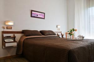 a bedroom with a bed with a brown blanket at Albergo La Rosetta in Chianciano Terme