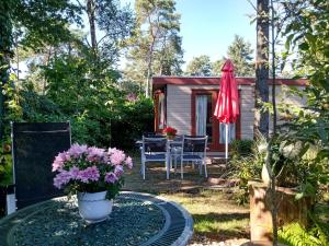a table with a vase of flowers on a table in front of a cabin at Jachtslot Chalet J8 in Doornspijk +6 photos