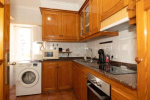 a kitchen with a washing machine and a microwave at Apartamento Puerto de Denia! Denia Port Apartment in Denia +8 photos