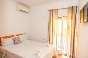 a white bedroom with a bed and a window at Apartamento Puerto de Denia! Denia Port Apartment in Denia