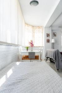 Un dormitorio blanco con una mesa y una ventana. en Las Gaviotas Suit - HOME RENT MALAGA, en Torre del Mar 10 fotos más