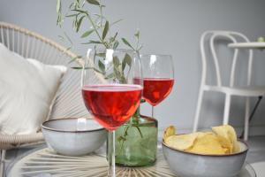 dos copas de vino y un tazón de patatas en una mesa en Musil Apartment, en Roma