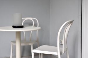 Una mesa y una silla blancas con una vela encima. en Musil Apartment, en Roma
