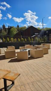 a group of chairs and tables on a patio at Arkhi Kokhta Bakuriani Apt 304 in Bakuriani