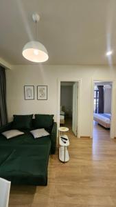 a living room with a green couch and a bedroom at Arkhi Kokhta Bakuriani Apt 304 in Bakuriani