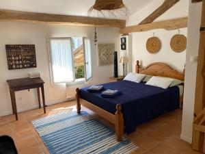 a bedroom with a bed with a blue comforter at Les volets bleus in Brie-sous-Mortagne