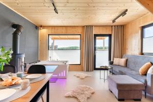 a living room with a couch and a table at Domek z Balią Jacuzzi Escape Kołobrzeg in Charzyno