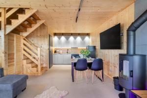 a kitchen and dining room with a table and chairs at Domek z Balią Jacuzzi Escape Kołobrzeg in Charzyno