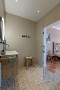 a bathroom with a sink and a bench in a room at Bed & Breakfast Casa del Palta in Canillas de Albaida