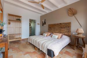 a bedroom with a large bed with a ceiling fan at Bed & Breakfast Casa del Palta in Canillas de Albaida
