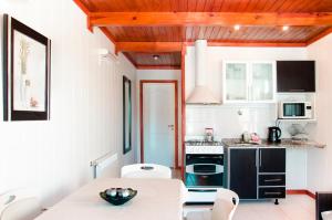 a kitchen with white walls and a table and chairs at Complejo 21 de Enero - Luz y Fuerza in Puerto Madryn
