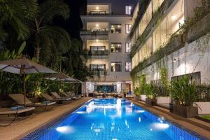a swimming pool in front of a building at night at Grand Yard La Residence in Siem Reap