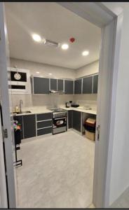 a kitchen with gray cabinets and a stove at Luxury Apartment In SALALAH in Salalah