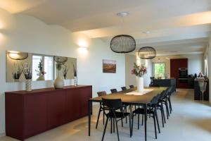 a dining room with a table and chairs at Villa Immersa Tra Le Vigne Con Piscina Riscaldata in Castiglione Tinella