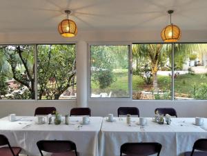 a room with tables and chairs and large windows at Quinta YaaxBe in Homún