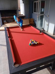 a young boy playing on a pool table at Hermosa casa en Lomas Del Rey in San Antonio de Arredondo